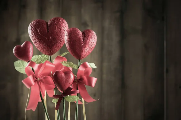 Flower in the shape of heart made from foam borad on brown wood — Stock Photo, Image