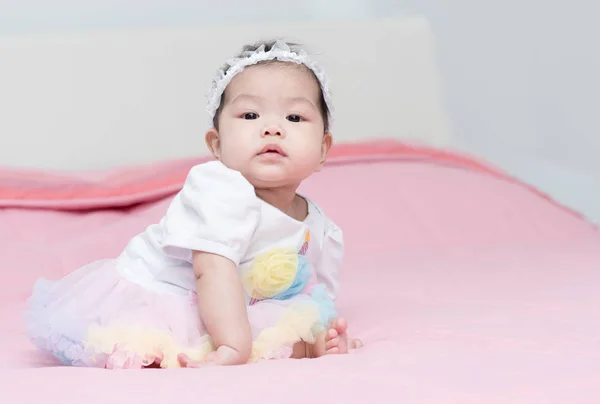 Grazioso bambino sedersi su una coperta rosa — Foto Stock