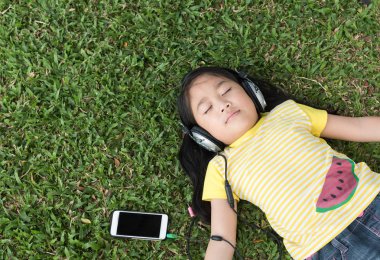 sevimli kız uzan ve cep telefonu müzik dinle 