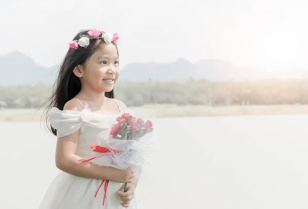 Aranyos kis menyasszony tart Rózsa csokor a természet háttér — Stock Fotó