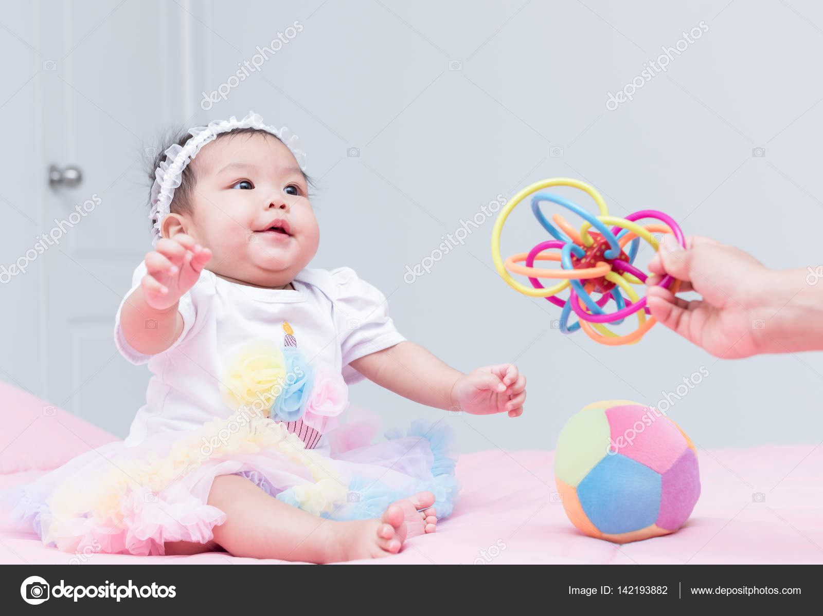 かわいい女の子の赤ちゃんは笑顔で母の手でおもちゃ遊び ストック写真 C Kwanchaichaiudom かわいい女の子の赤ちゃんは笑顔で母の手でおもちゃ遊び ストック写真 C Kwanchaichaiudom