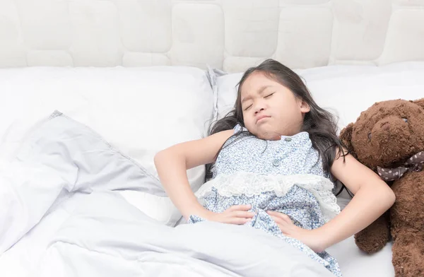 A little girl in her bed has a stomachache — Stock Photo, Image