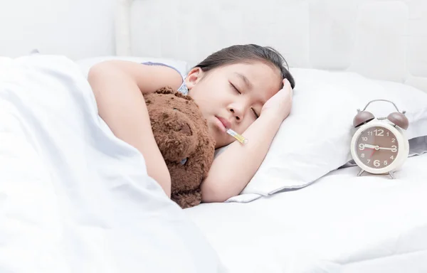 Sick girl with thermometer laying in bed. — Stock Photo, Image