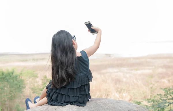 Carino ragazza tenendo smartphone per prendere selfie . — Foto Stock