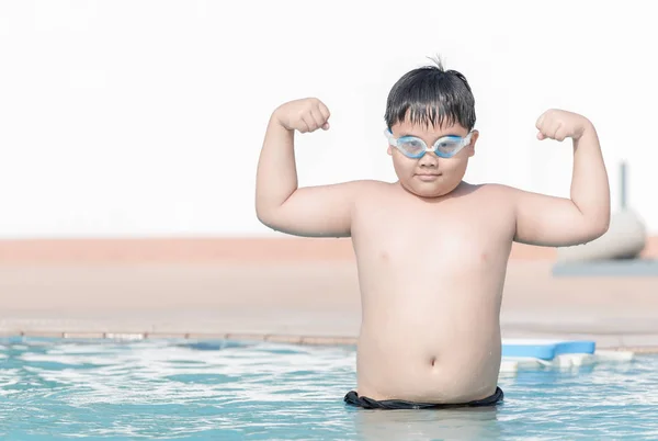 Fettleibige dicke Jungen zeigen Muskeln im Schwimmbad — Stockfoto