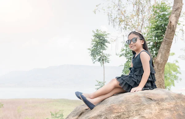 Linda chica sentarse en roca en la presa de fondo — Foto de Stock