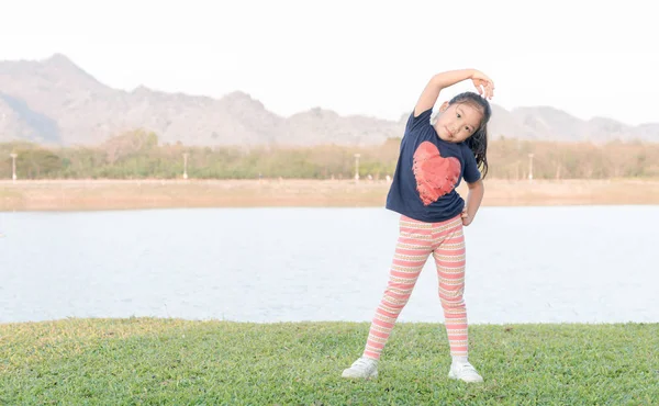 Süße asiatische Mädchen Übung auf grünem Gras — Stockfoto