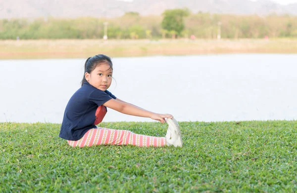 Süße asiatische Mädchen Übung auf grünem Gras — Stockfoto