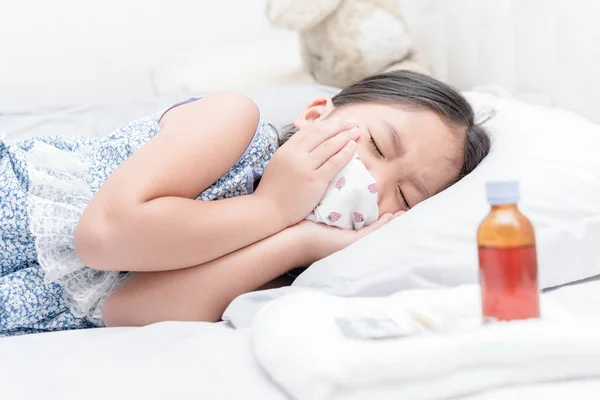 Chica enferma acostada en la cama y utilizar la máscara para dejar de estornudar — Foto de Stock