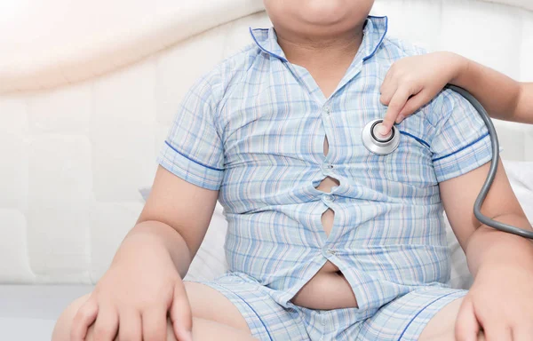 Läkare kolla hjärtat genom stetoskop till överviktiga asiatiska pojke — Stockfoto