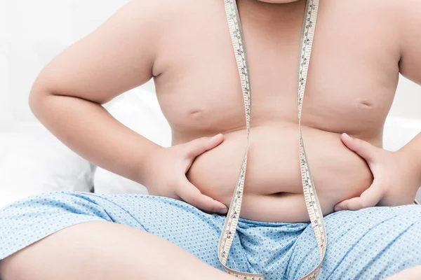 Obesidad niño gordo midiendo su vientre con cinta métrica — Foto de Stock