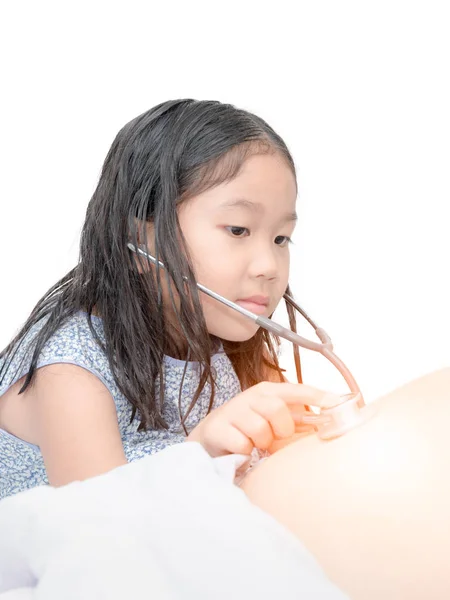 Schattig meisje met behulp van de stethoscoop selectievakje maag — Stockfoto