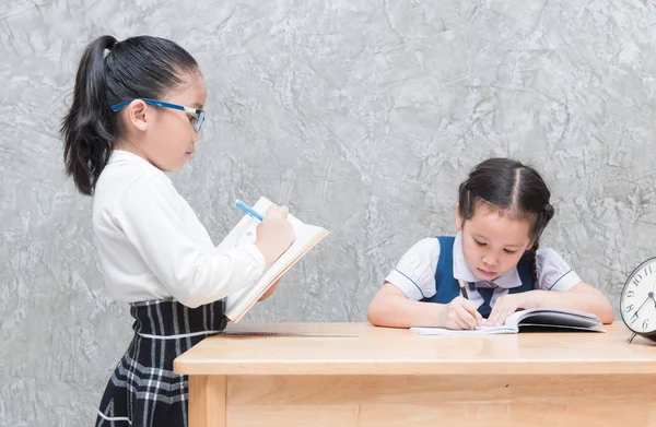 Lilla lärare skriva på boken och student uttråkad till gör homewo — Stockfoto
