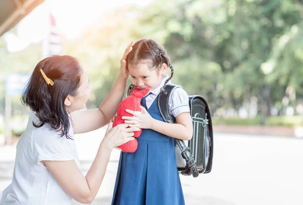 Мать, стоящая в школе, держась за руки и преподавая — стоковое фото
