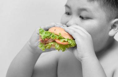 Hamburger obez çocuk el siyah ve beyaz arka plan üzerinde