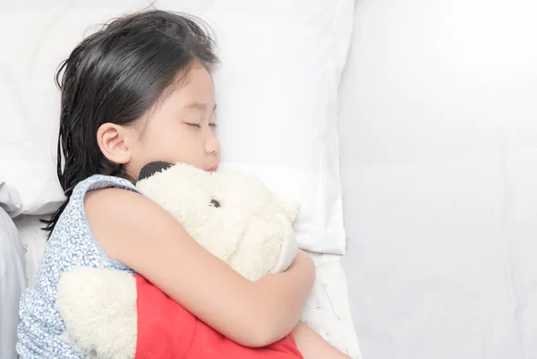 Niedlich wenig asiatisch mädchen schlaf und hug puppe — Stockfoto
