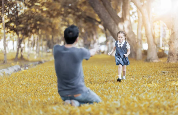 Studente bambini in uniforme che corre nelle mani del padre — Foto Stock