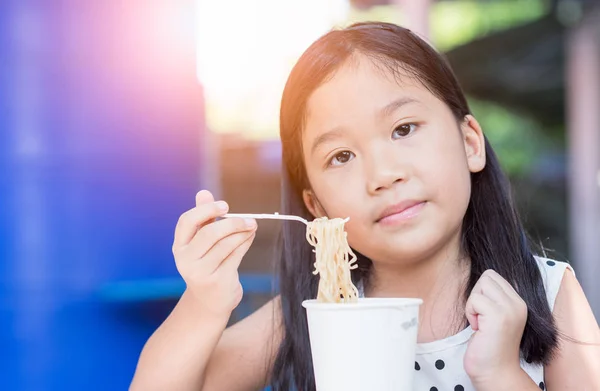 Lindo asiático niño chica comer instand fideos taza , — Foto de Stock