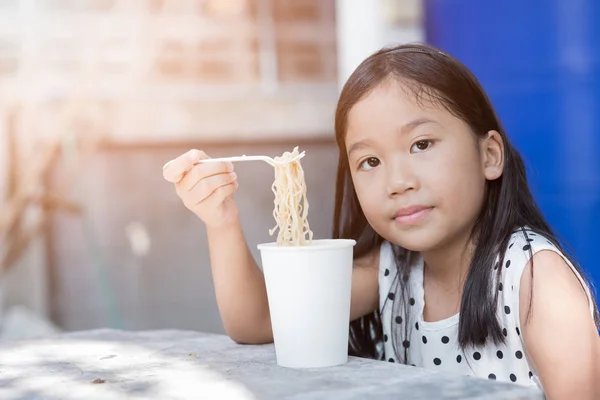 Lindo asiático niño chica comer instand fideos taza , — Foto de Stock