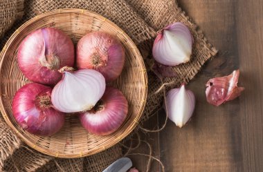 bambu sepet ve ahşap arka plan üzerinde kırmızı soğan dilimlenmiş.