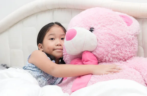 Lindo asiático pequeña chica abrazando Grande rosa oso — Foto de Stock