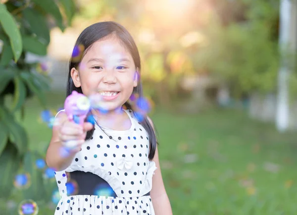 Feliz ásia menina jogar bolha sabão no casa — Fotografia de Stock