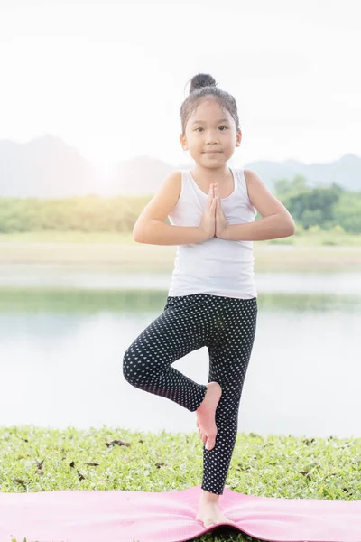 小さなかわいいアジアの女の子練習ヨガをポーズします。 — ストック写真