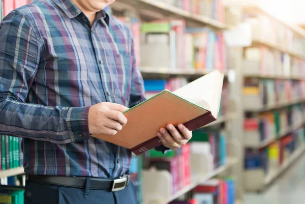 kitap ve Kütüphane arka planda tutan el öğrenci. 