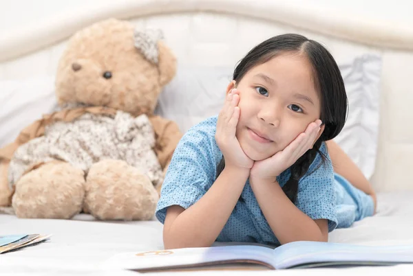 Lindo poco asiático chica leyendo cuentos de hadas en cama —  Fotos de Stock