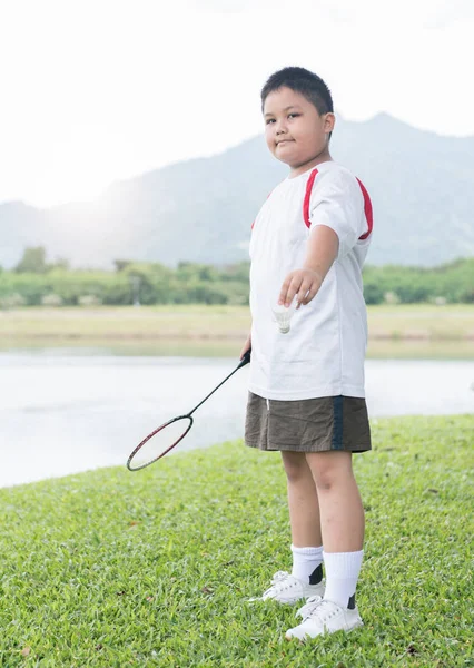 Zwaarlijvige fat boy spelen badminton — Stockfoto