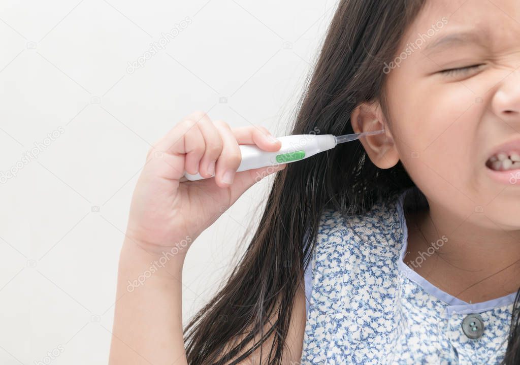 asian kid girl cleans her ear with ear pick, 