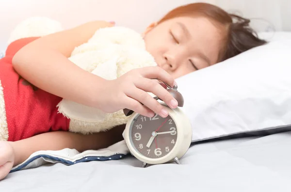 Pequeña mano chica llegar a apagar el despertador — Foto de Stock