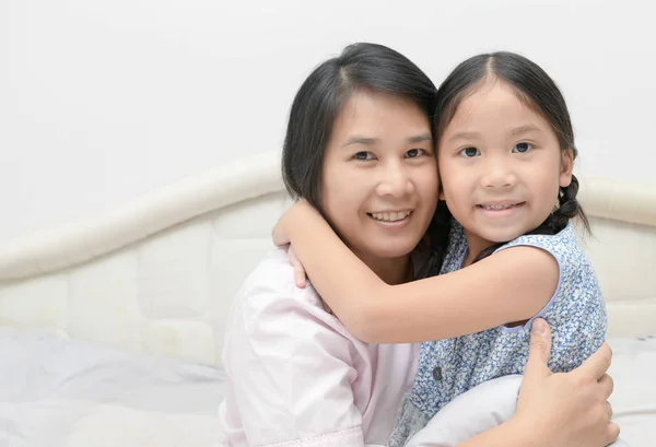 Madre e hija mirando a la cámara y sonriendo — Foto de Stock