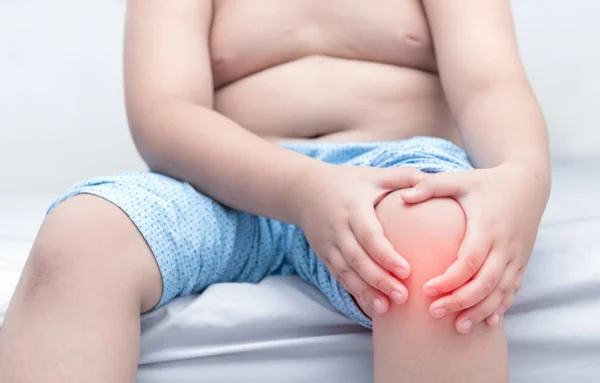 Niño gordo obeso que sufre de dolor de rodilla — Foto de Stock