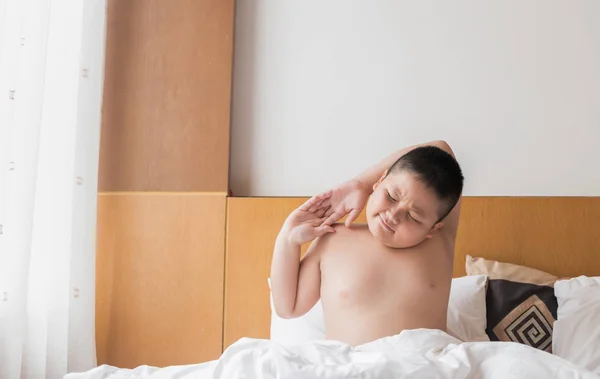 Niño obeso se despierta y se estira en la cama — Foto de Stock