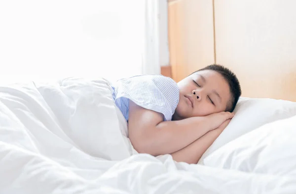 Fettleibige, dicke Jungen schlafen morgens auf dem Bett — Stockfoto