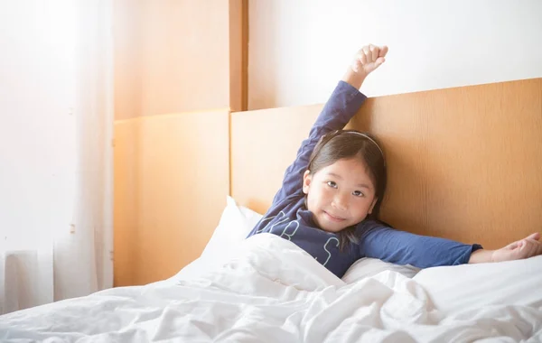 Asiática linda chica despierta y estiramiento en la cama — Foto de Stock