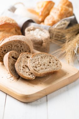 sliced baguette on wood block on white wood table