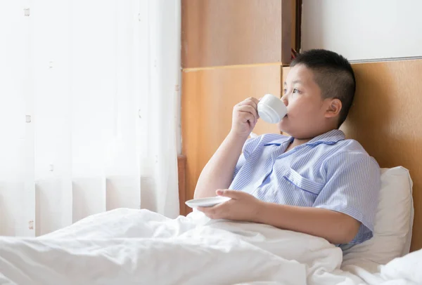 Gordito obeso bebiendo leche caliente en la cama — Foto de Stock