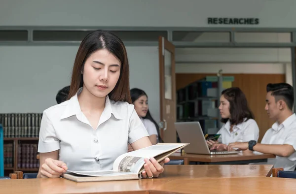 Cute asian student reading book in library university — Stock Photo, Image
