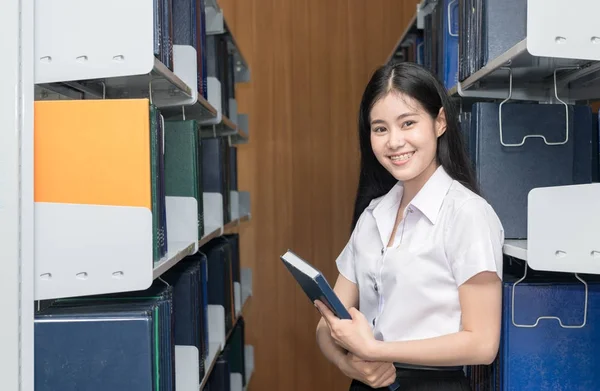 Aranyos ázsiai diák gazdaság könyv könyvtár — Stock Fotó