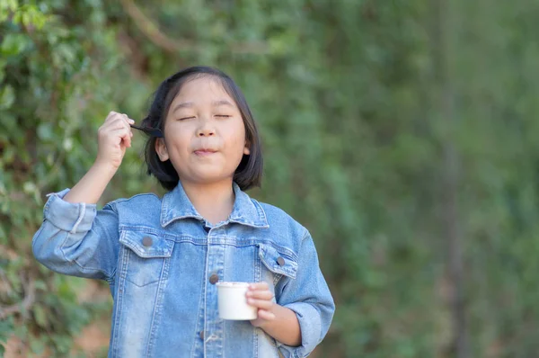 Cute asian dívka nosí džíny, sako si jíst zmrzlinu — Stock fotografie
