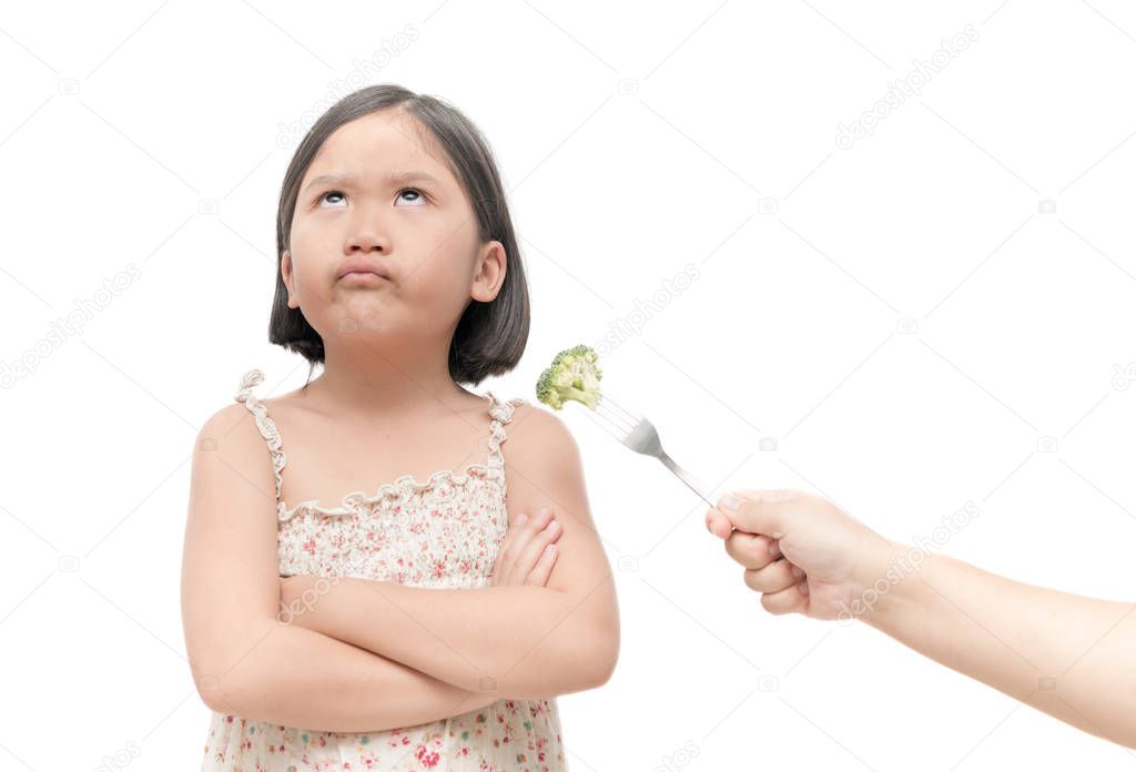 girl with expression of disgust against vegetables isolated 