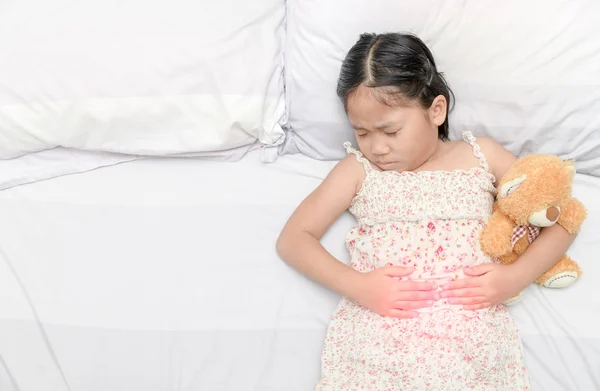 Chica asiática sufriendo de dolor de estómago — Foto de Stock