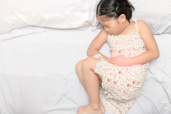 Asian girl suffering from stomachache — Stock Photo, Image