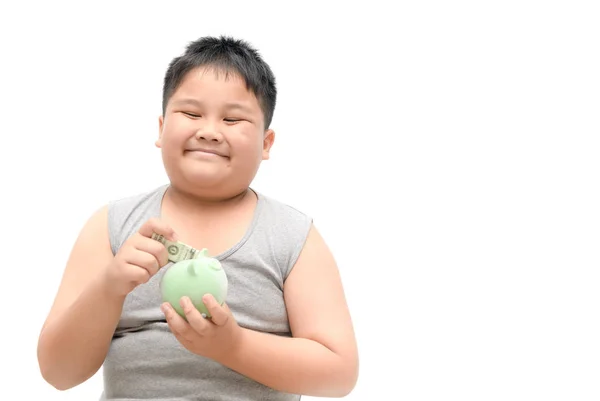 Мальчик улыбается и держит в руках банк свиньи — стоковое фото