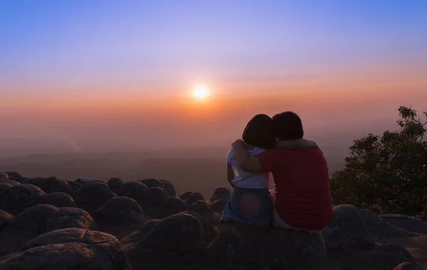 Αδελφός και αδελφή που κάθεται σε βράχο και να δείτε το ηλιοβασίλεμα μαζί — Φωτογραφία Αρχείου