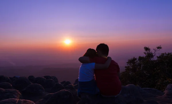 Αδελφός και αδελφή που κάθεται σε βράχο και να δείτε ηλιοβασίλεμα μαζί στο su — Φωτογραφία Αρχείου