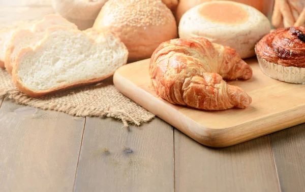 Homemade croissant and bread on old wood — Stock Photo, Image