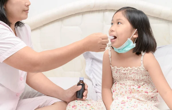 Mor ger hennes dotter sirap på grund av influensa — Stockfoto